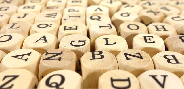 Buchstaben auf Würfel. Symbolbild für einen Text ohne Vokale mit allen Buchstaben.