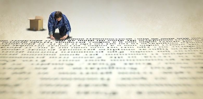 Ein Mann legt Buchstaben auf den Boden. Symbolbild für den Text ohne Konsonanten - Die Auflösung (Text mit allen Konsonanten).