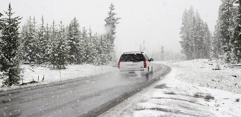 Ein Auto fährt im Winter durch den Schnee. Symbolbild für die 3 Spritspar-Tipps für den Winter.