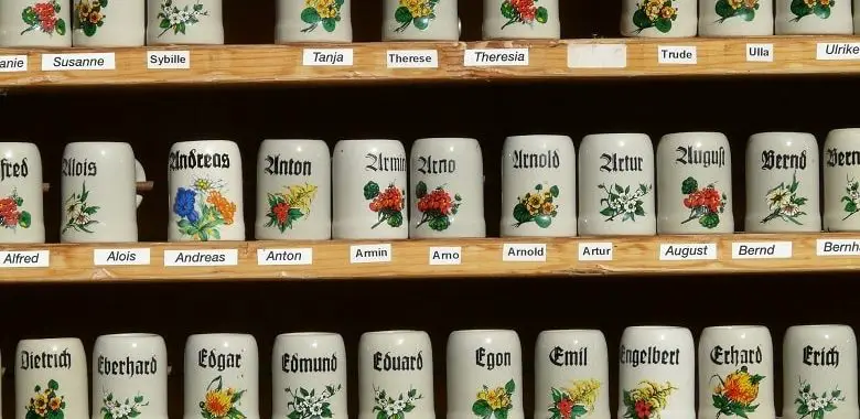 Krüge in einem Regal, auf denen verschiedene männliche Vornamen stehen. Symbolbild für die 100 häufigsten männlichen Vornamen in Deutschland.
