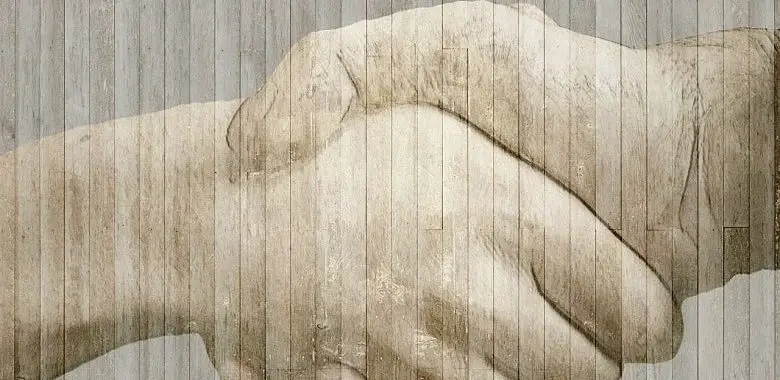 Zwei Hände beim Händeschütteln. Symbolbild für den Text mit der Erklärung des Sprichworts "Eine Hand wäscht die andere."