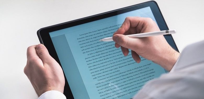 Ein Mensch schreibt mit einem Stift auf einem iPad. Symbolbild für eine iPad-Klasse.