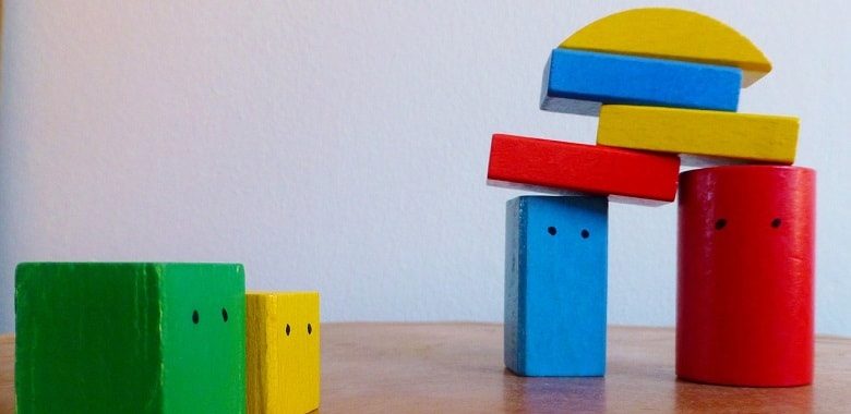 Bunte Bauklötze vor einer weißen Wand. Symbolbild für Herkunft und Erklärung der Redewendung "Bauklötze staunen".