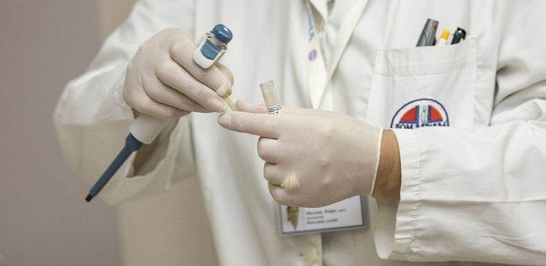 Die Hände eines Arztes in Schutzhandschuhen. Symbolbild für Erklärung und Herkunft des Wortes Quarantäne.
