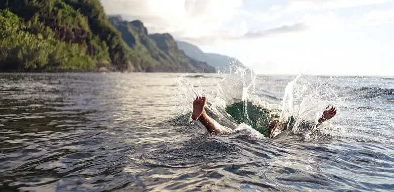 Ein Mann springt ins Wasser. Symbolbild für die 100 Wörter über Genuss.