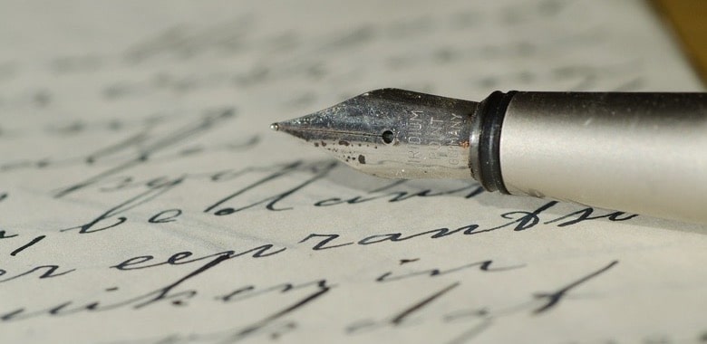 Ein Füller liegt aus einem Papier, welches mit einer alten Schrift beschrieben wurde. Symbolbild für den Beitrag "Besonderer Buchstabe: Das Eszett".