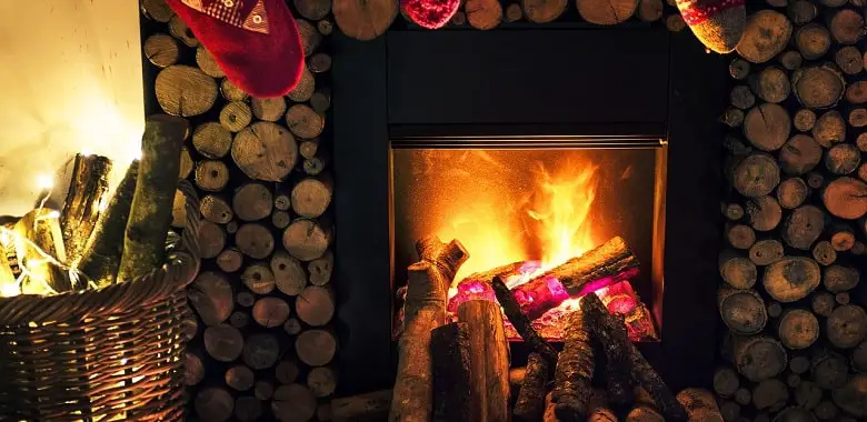 Ein Kamin mit brennendem Holz. Symbolbild für den Monat Dezember und die Herkunft und Erklärung seines Namens.