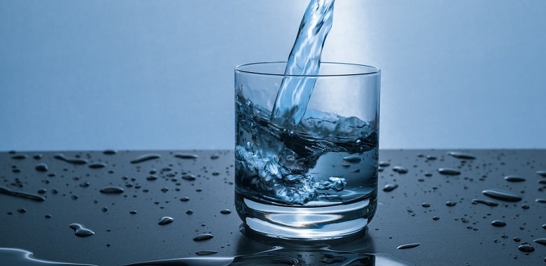 Wasser wird in ein Glas gegossen. Symbolbild für die Erklärung, was eine Wasservergiftung ist.