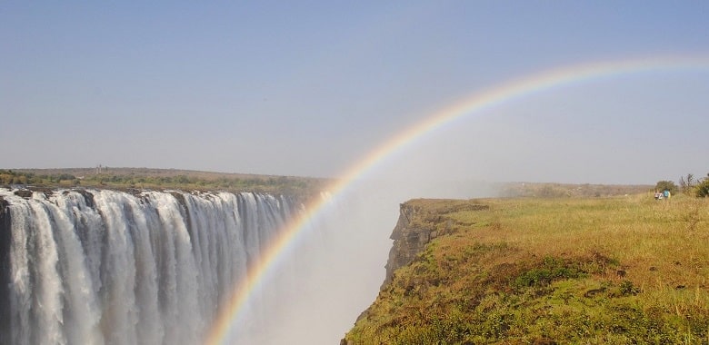 Die Viktoriafälle mit einem Regenbogen. Symbolbild für spannende Fakten über das afrikanische Land Simbabwe.
