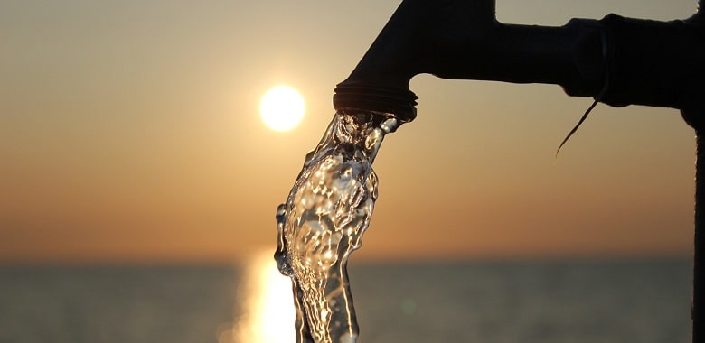Nahaufnahme eines Wasserhahns, aus dem Wasser fließt. Symbolbild für die Erklärung von Wasserfasten und ob es gesund oder gefährlich ist.