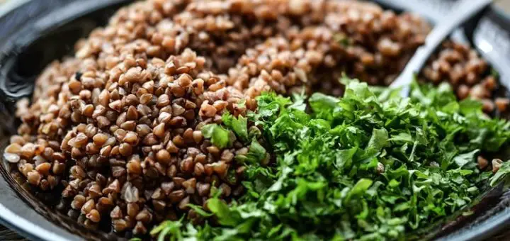 Nahaufnahme von gekochtem Buchweizen mit Salat. Symbolbild für die Erklärung, was Buchweizen ist.