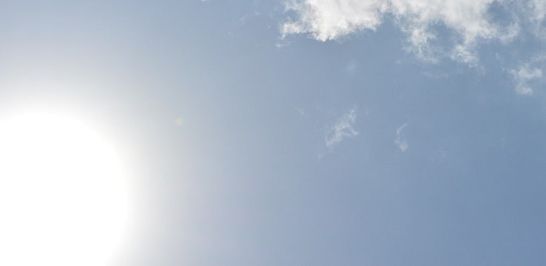 Die Sonne scheint an einem blauen Himmel heiß an einem Sommertag. Symbolbild für die Erklärung, wie man mit dem Tipp, die Verdunstungskälte zu nutzen, einfach Getränke kühlt.