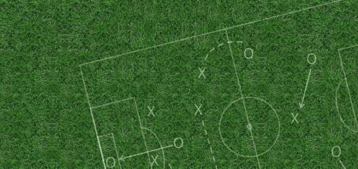 Eine Taktiktafel auf einem Fußballfeld. Symbolbild für die Erklärung des Unterschieds von Strategie und Taktik.