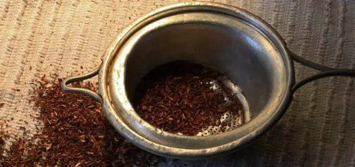 Ein Teesieb mit Rooibos. Symbolbild für die Erklärung, was Rooibos bzw. Roibusch ist.