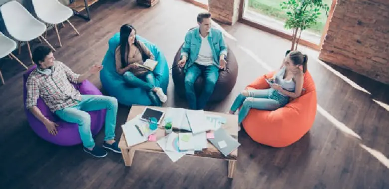 Mehrere Personen sitzen auf gemütlichen Sesseln im Kreis. Symbolbild für ein modernes Klassenzimmer mit Chillout-Lounges.