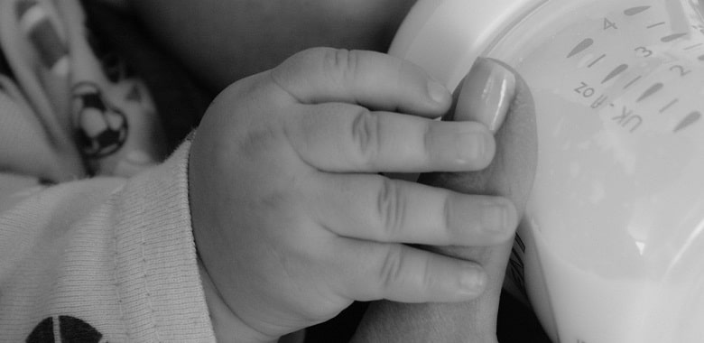 Nahaufnahme einer Mutter mit Baby, das aus der Flasche trinkt. Symbolbild für die Erklärung, ob jede Mutter ihr Baby stillen kann.
